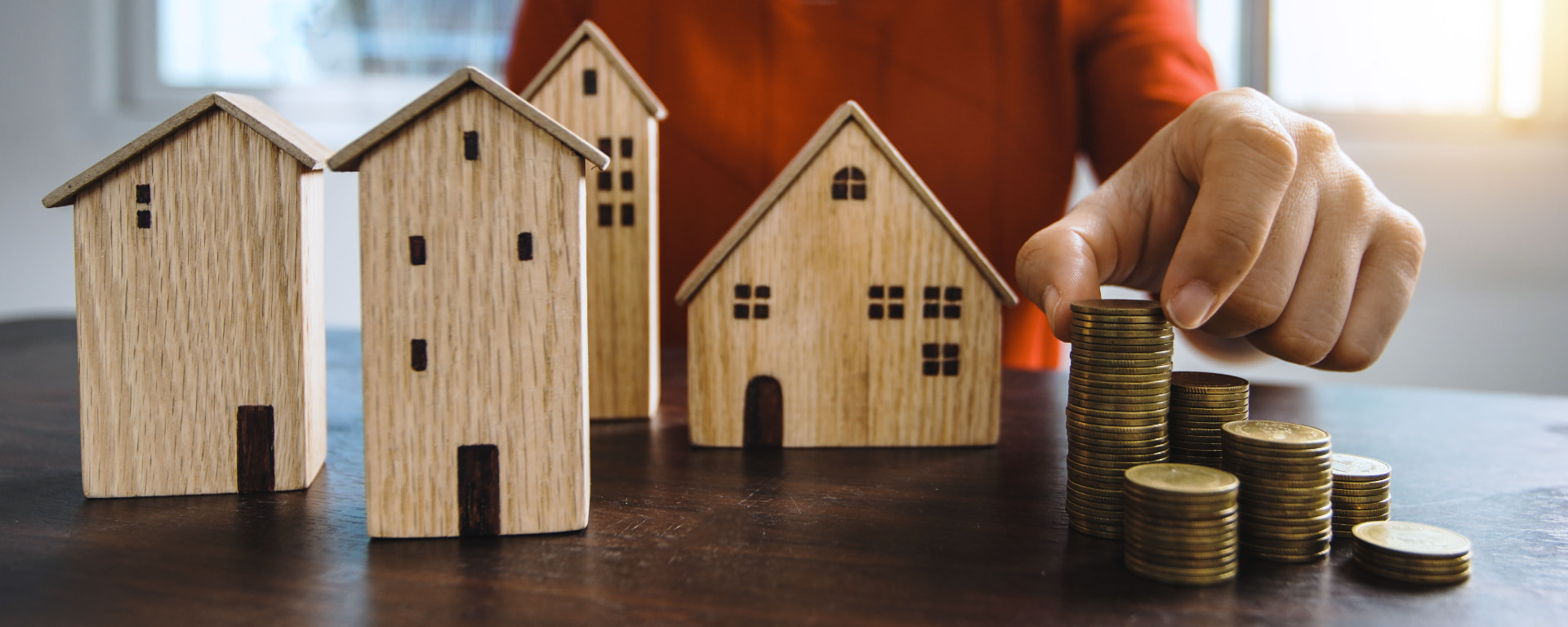 Casas em miniatura e moedas para planejamento de longo prazo